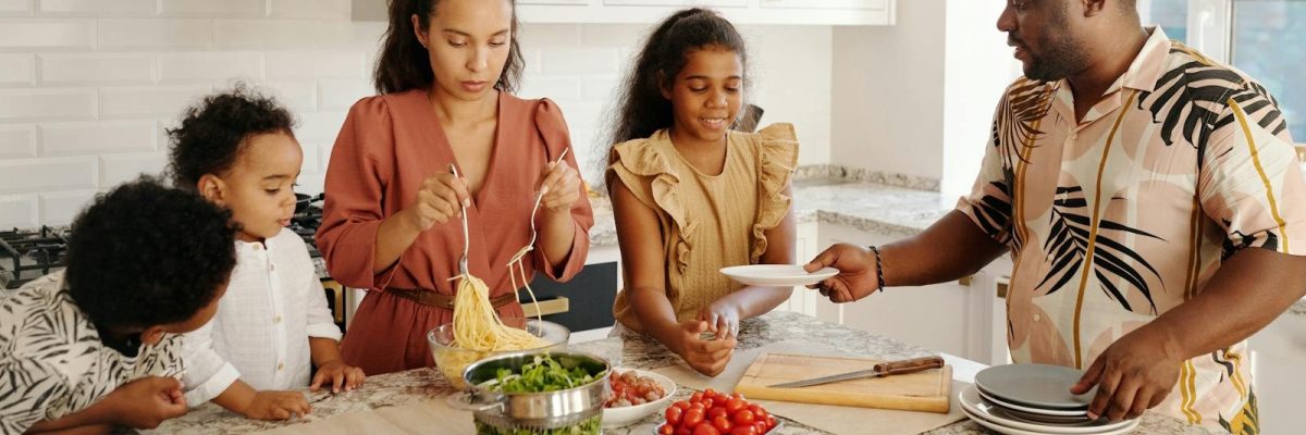 A diverse family preparing a meal together in a bright, modern kitchen setting.